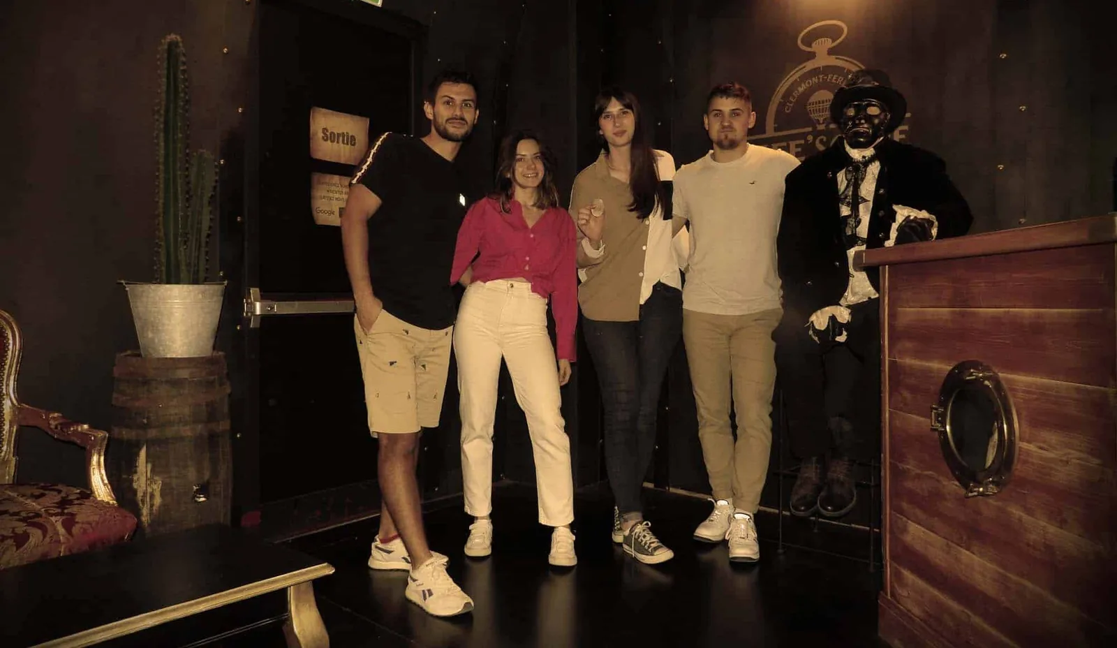 Un groupe d’amis souriant après avoir terminé un escape game, heureux·ses d’avoir relevé le défi ensemble.