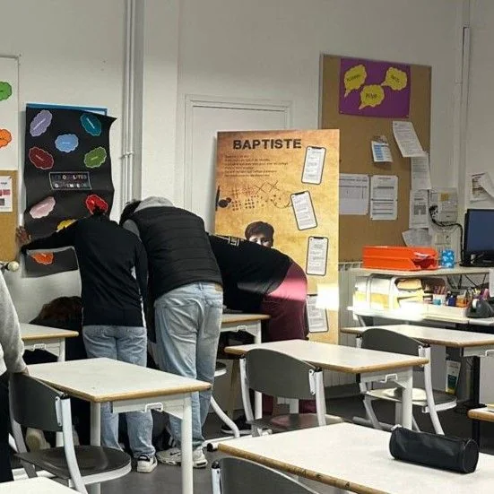 Élèves penché·e·s sur les indices d'un Escape Mobile de sensibilisation, en pleine enquête