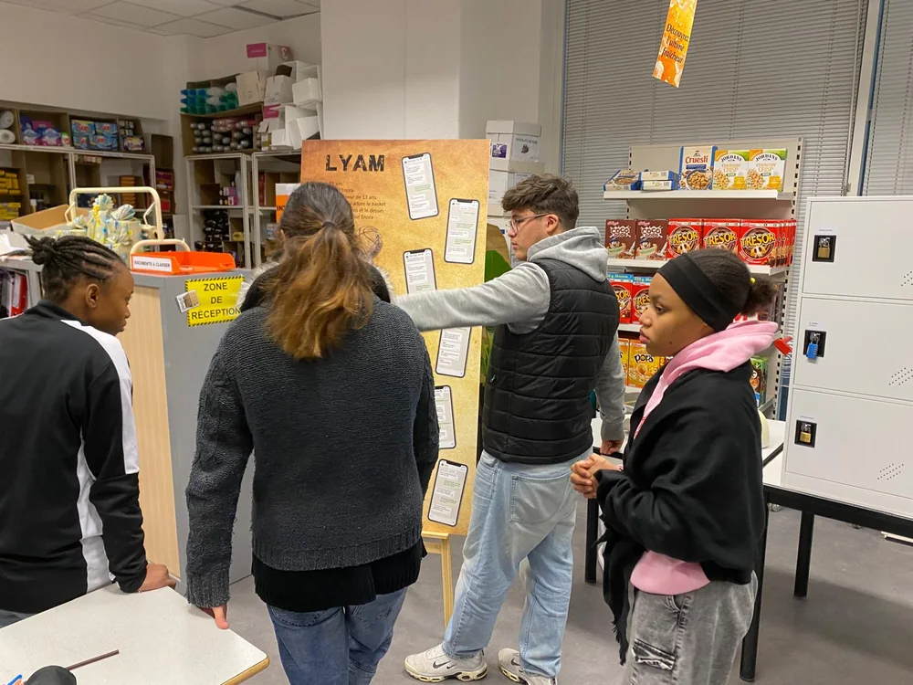 Groupe d'adolescent·e·s rassemblés autour du panneau d'indices d'un Escape Mobile, en salle de classe